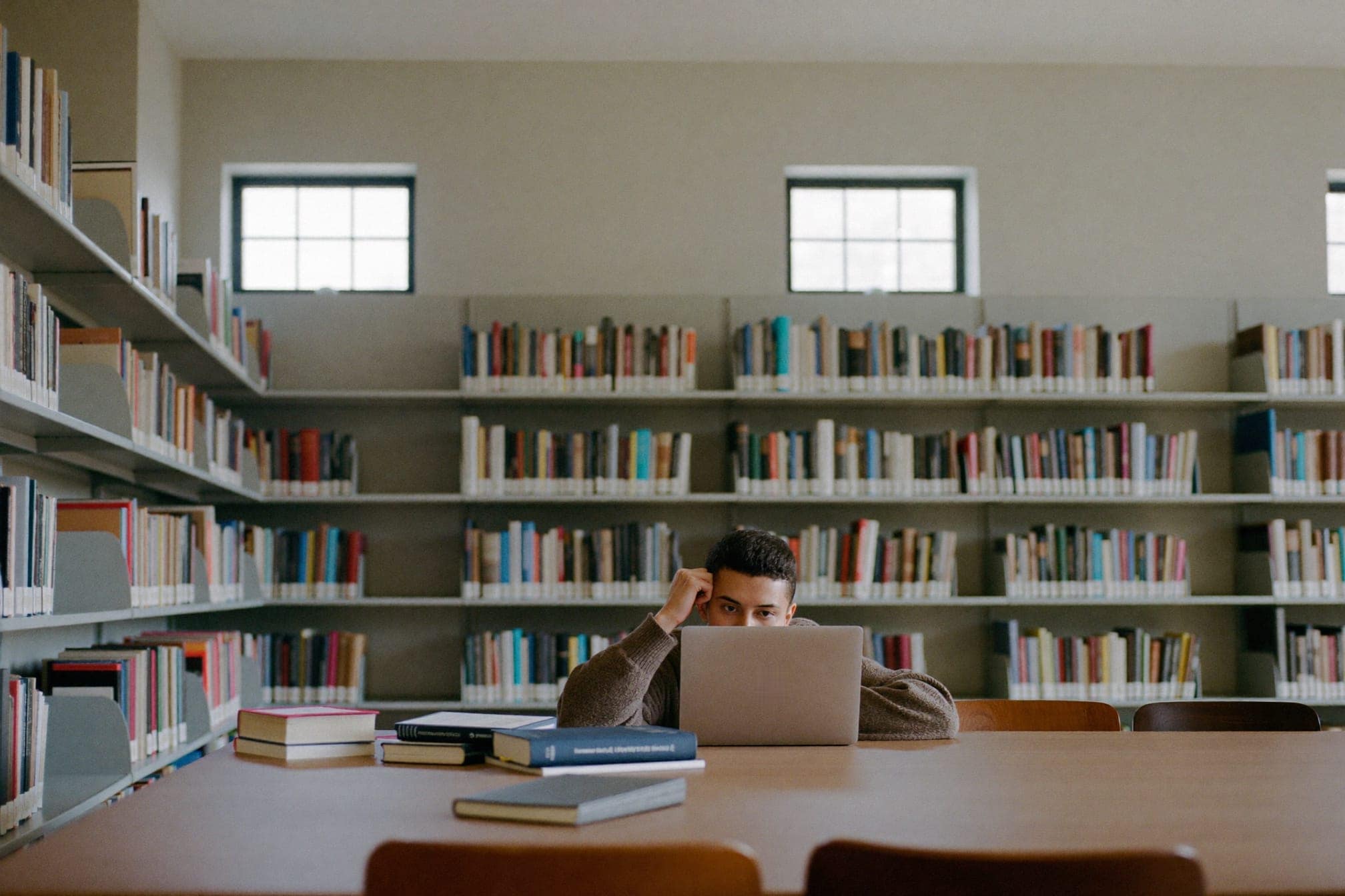 A person studying at a table in a bright library