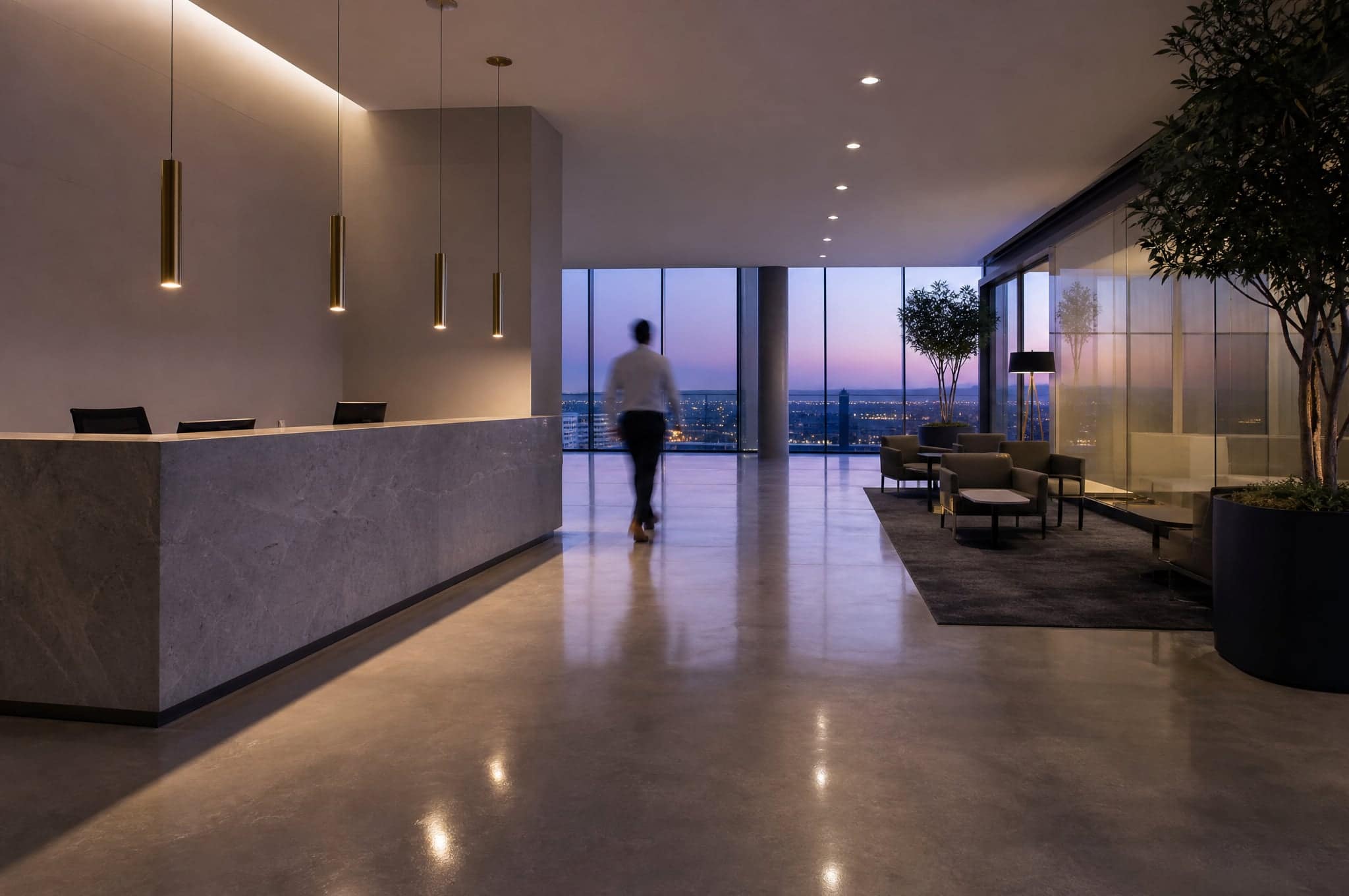 A quiet reception area at dusk with one person walking through