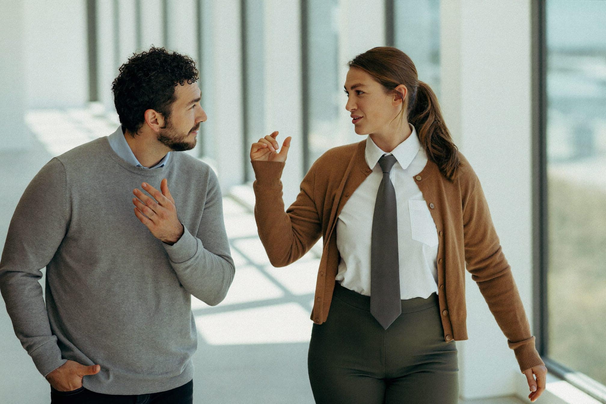 Two colleagues talking in an office corridor